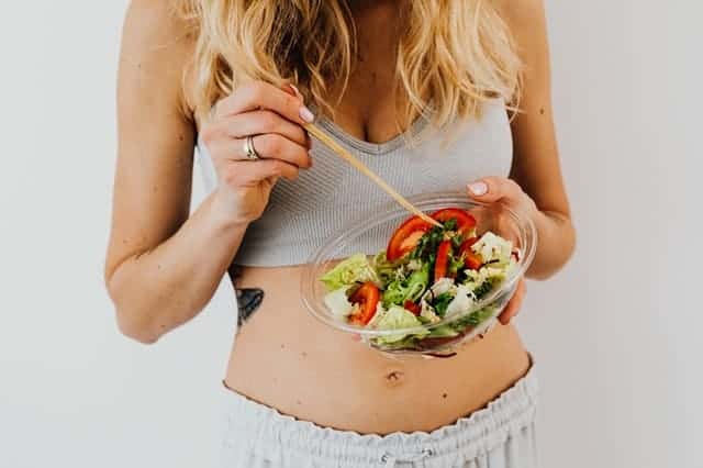 A woman eats a salad