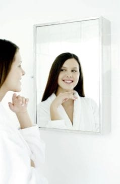 a woman looks in the mirror