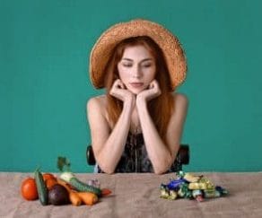 Woman wonders whether to eat candy or vegetables