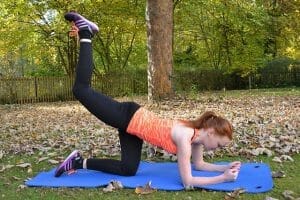 a woman exercises in a park