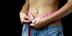 woman measures waist circumference