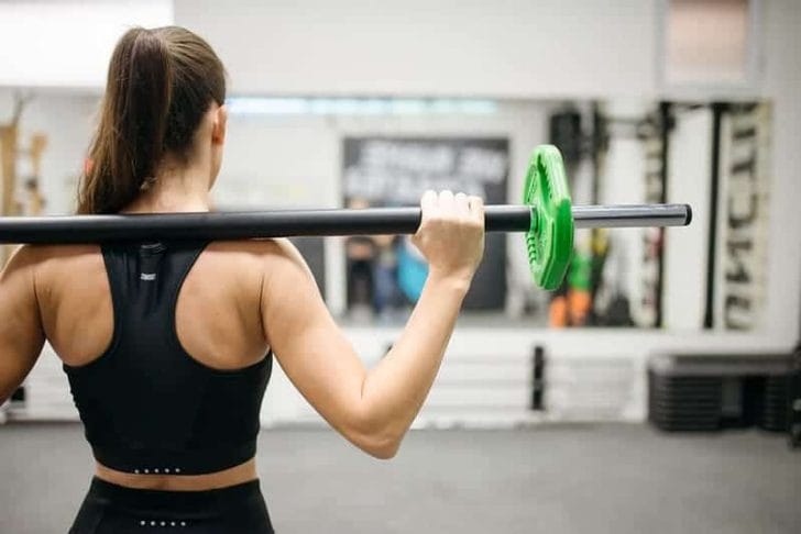 woman trains with barbell