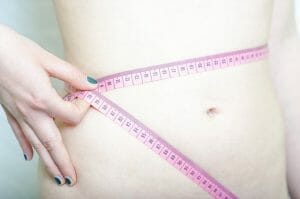 Slim waist, measuring waist with a centimeter