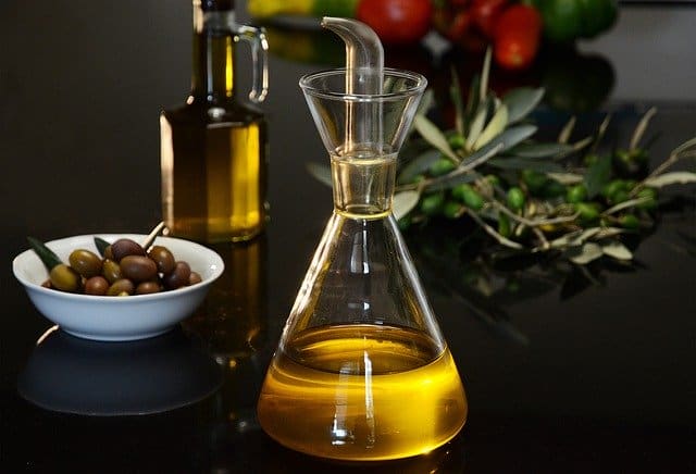 a bottle of olive oil and green olives