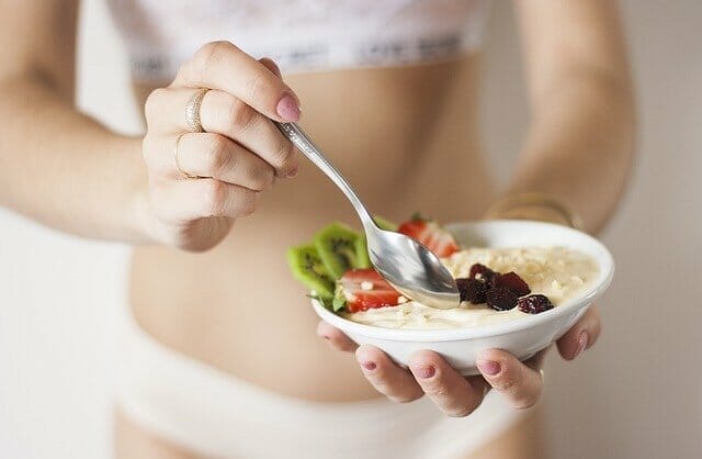 Woman holding a salad bowl with oatmeal, weight loss diet