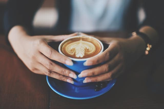 A cup of coffee held in the hands