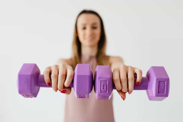woman exercises with dumbbells