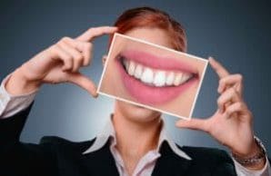 woman shows us a photo of her teeth