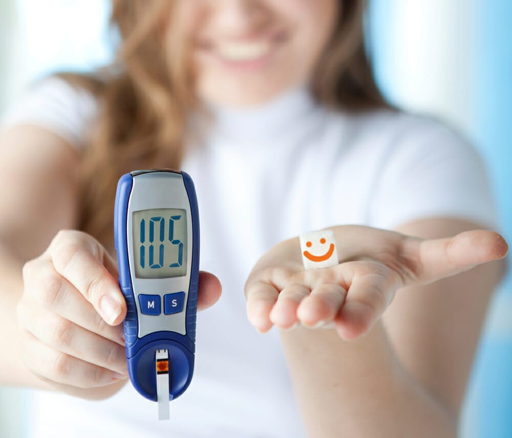  a woman shows a glucometer, which shows the correct result