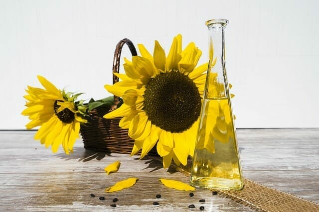  A flacon of oil next to sunflowers