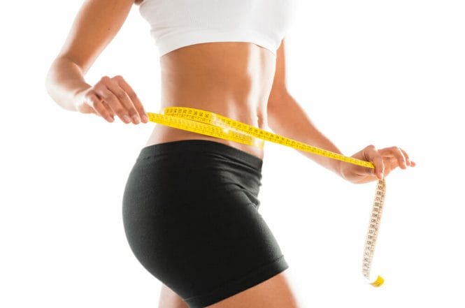 woman measures her waist with a centimeter