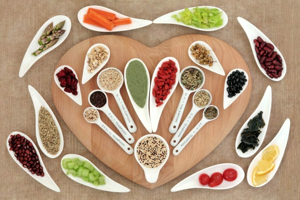  Herbs and other healthy products lie on a heart-shaped cutting board