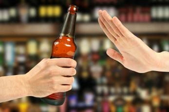  hand stops the bottle of alcohol