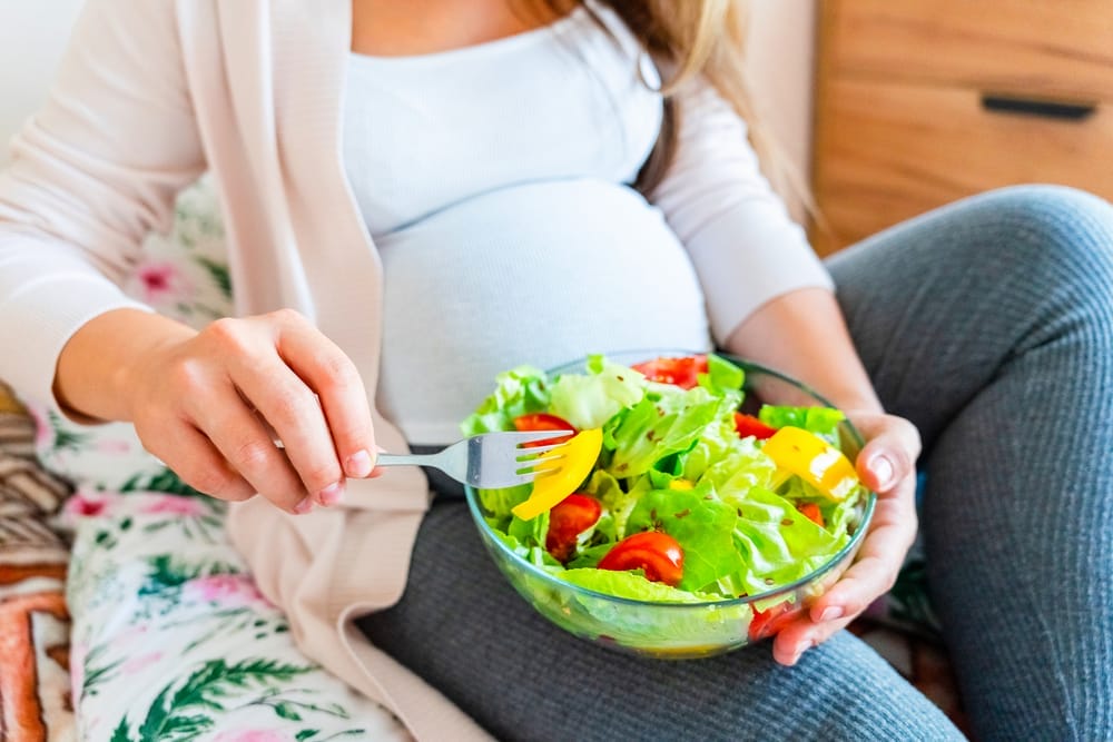  pregnant woman eats salad
