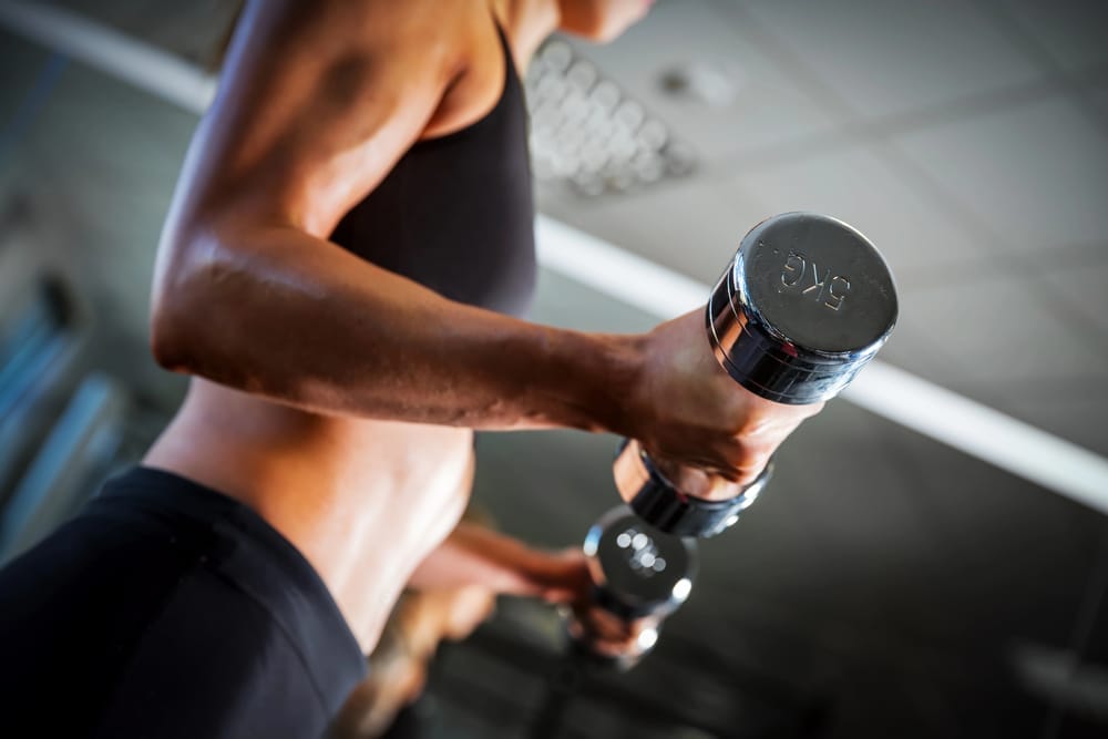 woman exercises with dumbbells